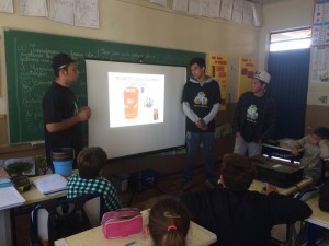 estudantes apresentando o projeto turma dos anima lixo para crianças em uma sala de aula