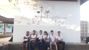 Estudantes em frente ao painel que pintaram na escola