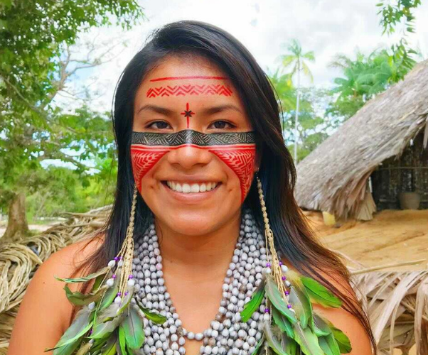 Jovem indígena com pintura facial e acessórios
