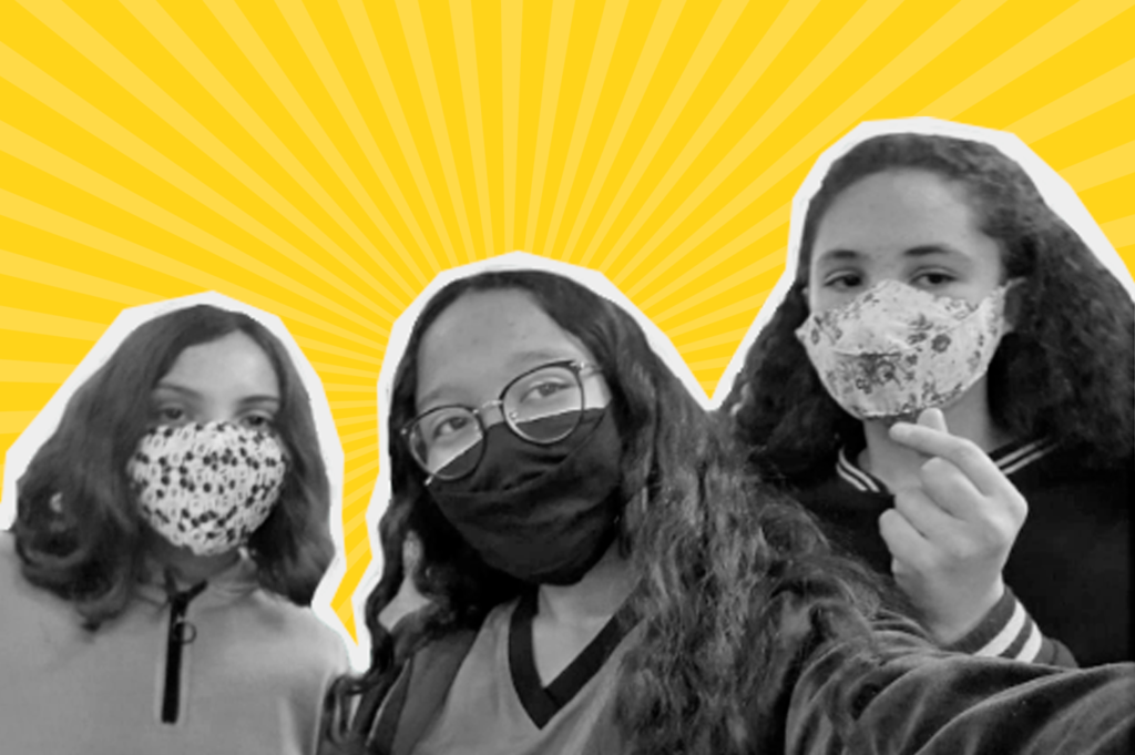 Recorte de foto em preto de branco de três meninas num fundo amarelo. A da esquerda tem cabelo liso, a do meio ondulado e da direita cacheado. Todas usam máscaras e da do meio usa óculos.