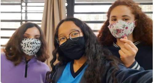 Selfie de três meninas, duas brancas e uma negra, usando mascará